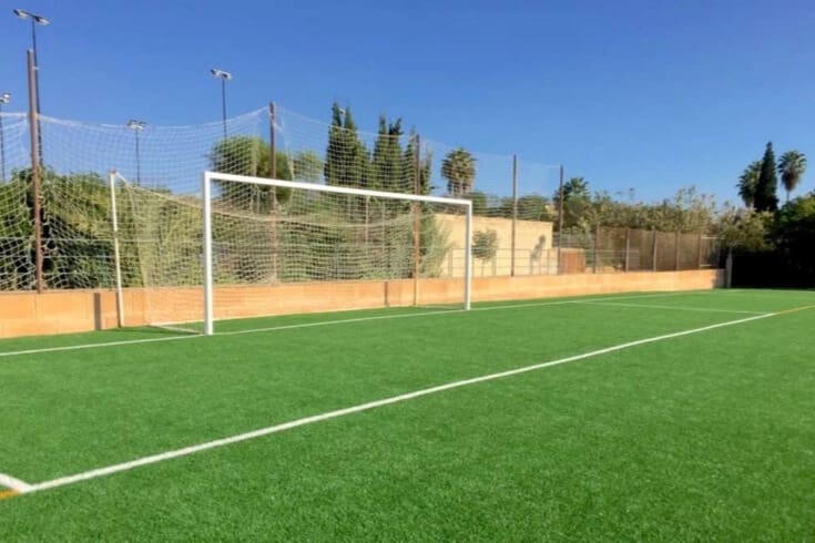 Fussballfeld mit Tor und mediterraner Umgebung